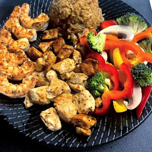 Hibachi grilled chicken and shrimp with fried rice and vegetables